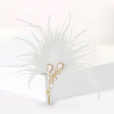 Grouped view of long feather plume brooch with a small clear crystal bow arranged together.