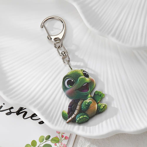 Green turtle acrylic keychain with silver clasp on white dish