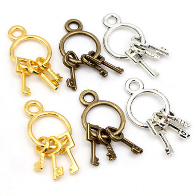 Grouped front view of mini key ring charms with three dangling keys in four finishes