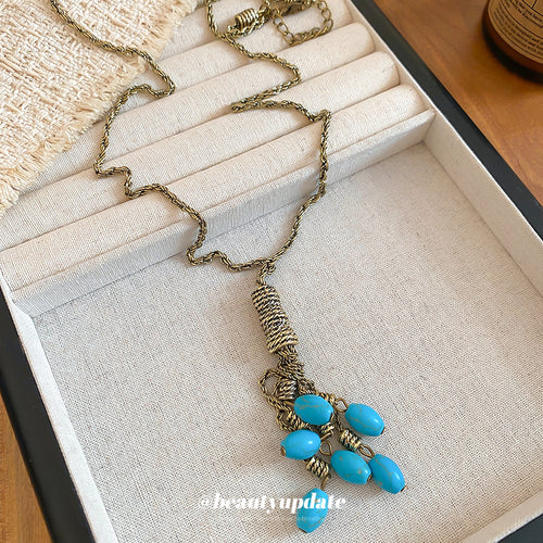 Close view of the colors and surface details on turquoise blue stone tassel necklace