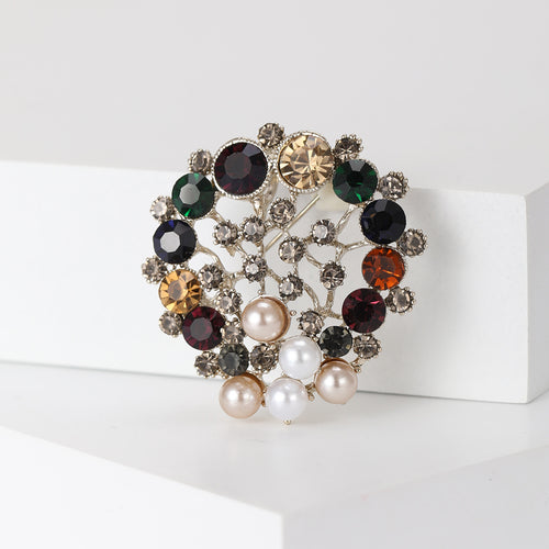 Angled view showing the round jeweled wreath brooch surface