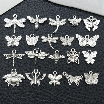 Blue bee and butterfly charms arranged on a light background