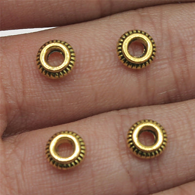 Antique Bronze, Antique Gold, Antique Silver ridged ring spacer bead front view on fingertips