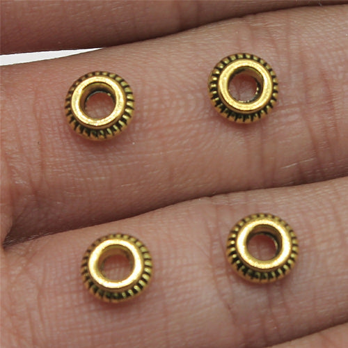 Antique Bronze, Antique Gold, Antique Silver ridged ring spacer bead front view on fingertips