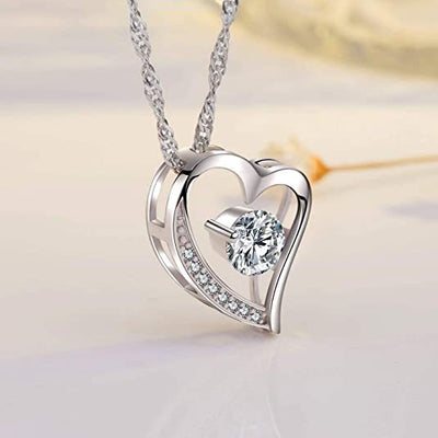 Silver open heart CZ pendant necklace hanging on soft pink backdrop
