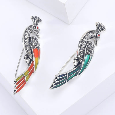Front view of the crystal peacock brooch showing a silver-tone crystal peacock with long striped enamel tail