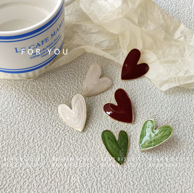 Three color heart enamel studs green wine cream on table