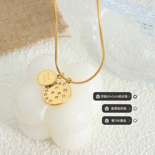 Gold Good Luck disc necklace on white prop with size material labels