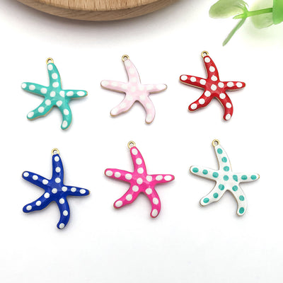 Gold-tone starfish charms arranged on a light background