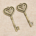 Long Heart Bow Key Charm in an Antique Bronze Finish view 2