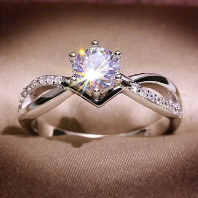 Product view showing silver-tone infinity ring with a round center stone