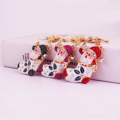 Three Santa stocking keychains in green, rose red and red rhinestone colorways.