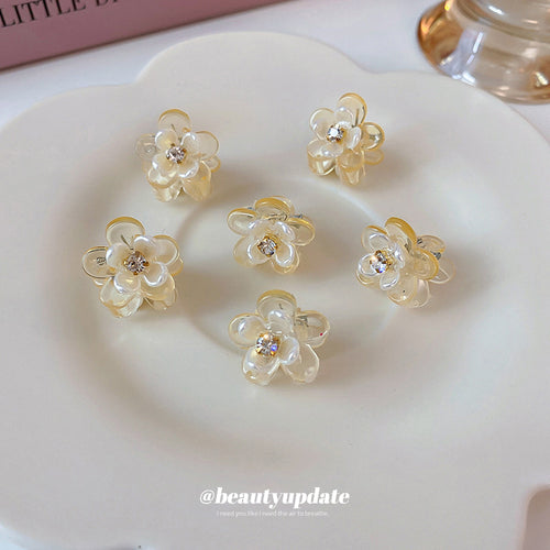 champagne-clear flower mini hair claws with small crystal centers shown worn in a styled second view