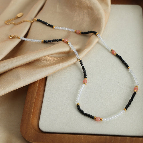 Full beaded necklace with gold clasp and extension on tray and silk fabric