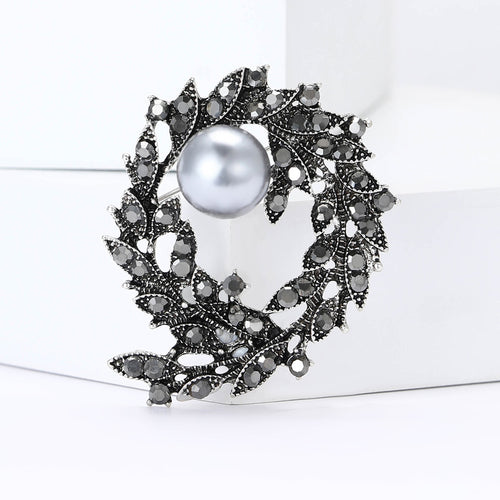 珍珠水钻枝叶花环 brooch shown from the front on a white background