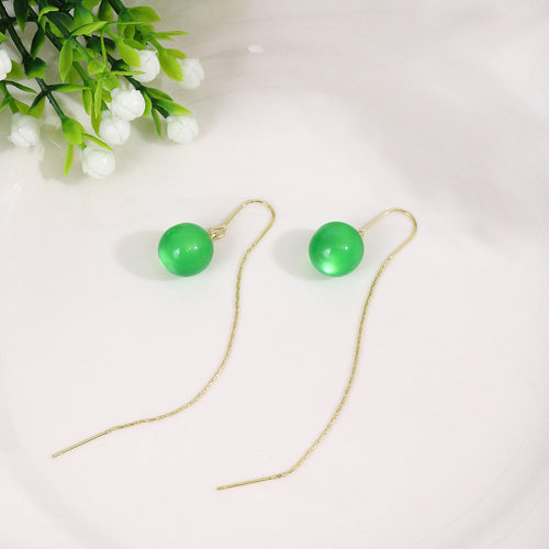 Green bead threader drops on white plate with small white flowers