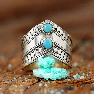 Front view of antique silver V dual turquoise cabochon ring on wood