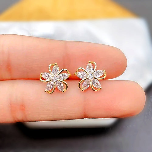 Gold flower marquise studs resting on fingertips