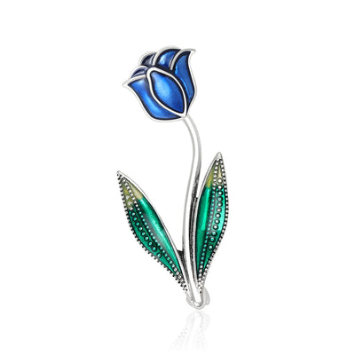 Blue enamel rosebud brooch with green leaves front on white