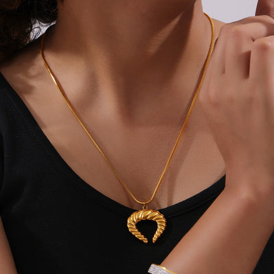 Gold twisted horn pendant necklace worn with black top