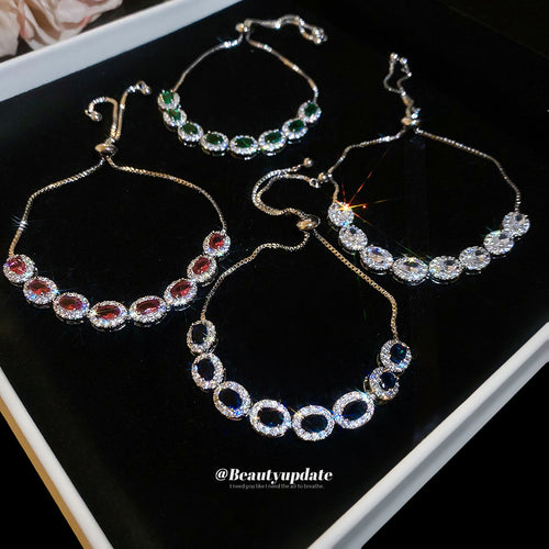 oval halo crystal slider bracelet in blue, clear, green, or pink shown worn in a styled second view