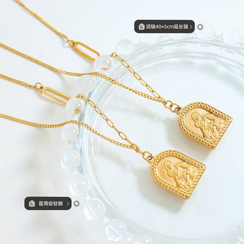 Two gold Madonna child pendants on glass with length and steel labels