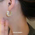 White Flower and Crystal Hoop Earrings in Polished Gold Tone view 3