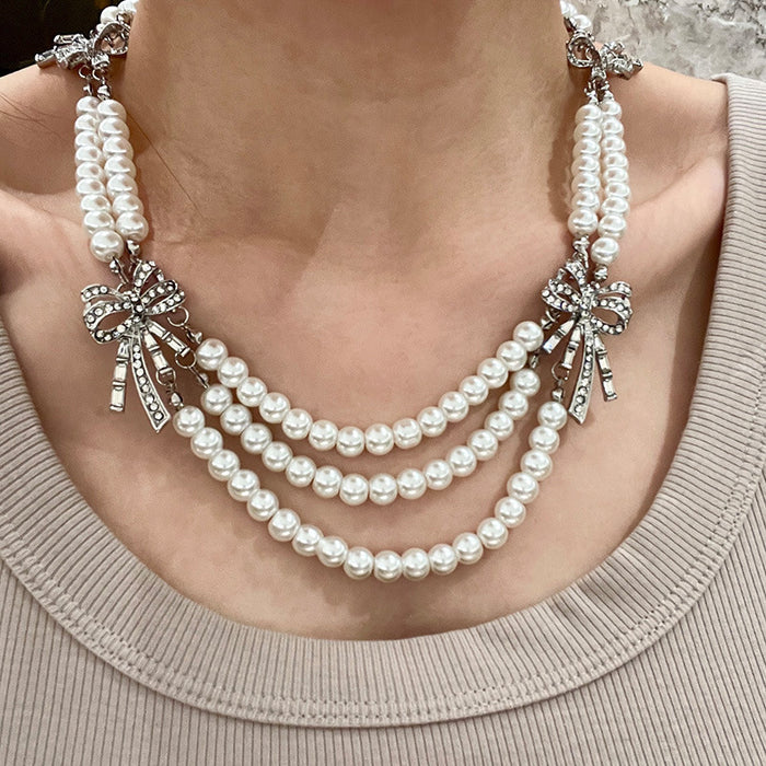 Triple Strand Faux Pearl Necklace With Crystal Bows