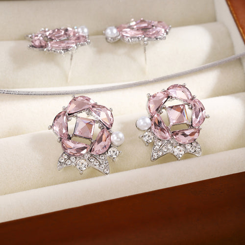 Pink rose crystal stud pair focused in cream jewelry box with chain