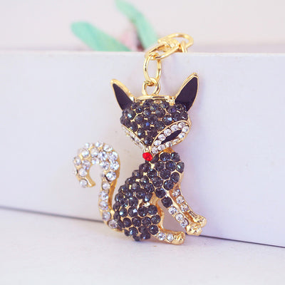 Angled front view of a dark rhinestone fox charm with clear crystal tail accents.