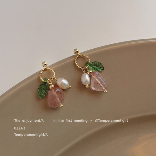 Gold-tone green-leaf pink-flower white-pearl studs in the first product display.