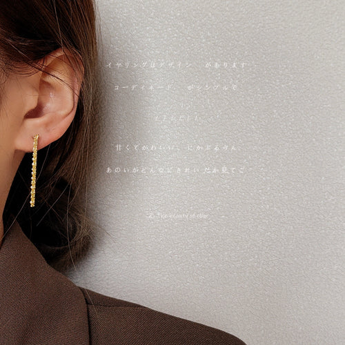 Gold twisted rope bar earring worn on ear side view