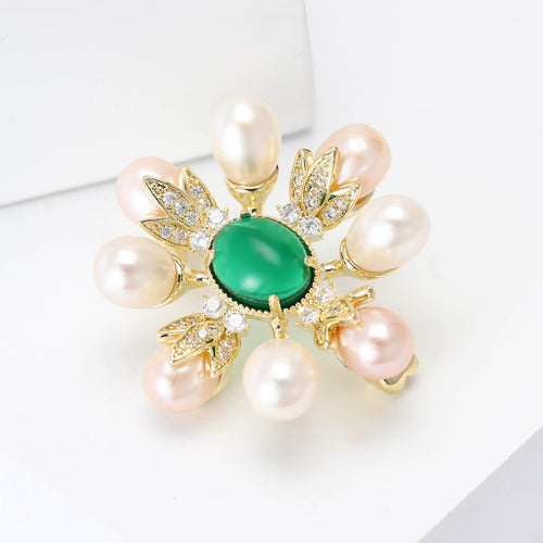 Gold pearl green center brooch angled on white display blocks