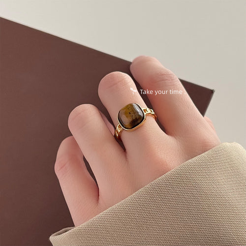 Gold-tone brown-banded-square-stone adjustable open ring shown worn on a hand.