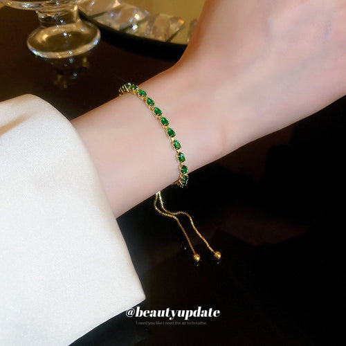 two slider bracelets with green stones or silver-tone crystal clusters shown worn in a styled second view