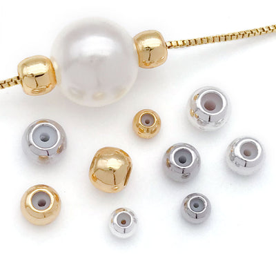 Gold-tone slider bead jewelry findings arranged on a light background