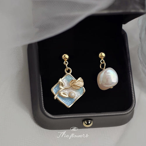 Asymmetric blue enamel flower and pearl drop earrings in black jewelry box