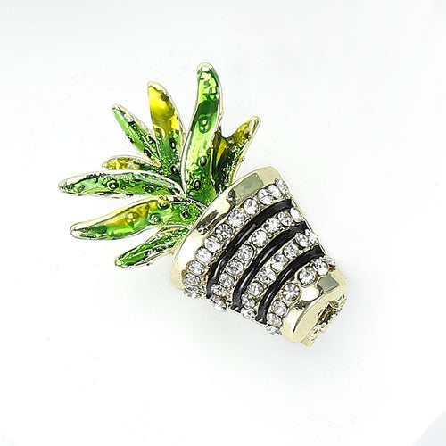 A green cactus rising from a striped crystal planter shown in a styled display.