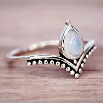 Antique silver V ring teardrop moonstone on wood close-up