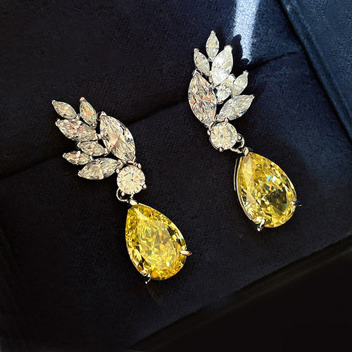Yellow pear drop leaf crystal earrings on black velvet display