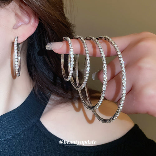 silver tone crystal hoop earrings shown in a clear product view
