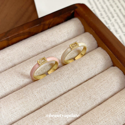 Pink and white enamel zircon rings on fabric ring rolls