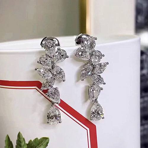 Pair of cascade drop earrings resting on white ceramic mug rim