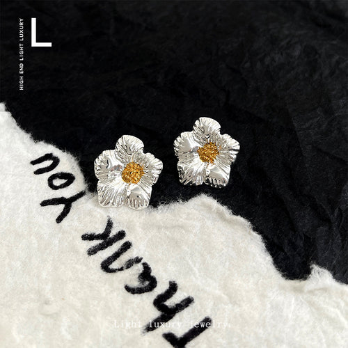 Silver gold flower studs on black and white knit fabric prop