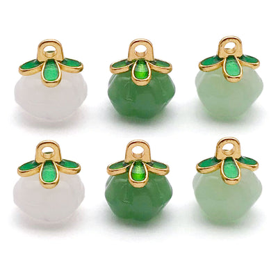 Colorful four-leaf clover and pumpkin charms arranged on a light background