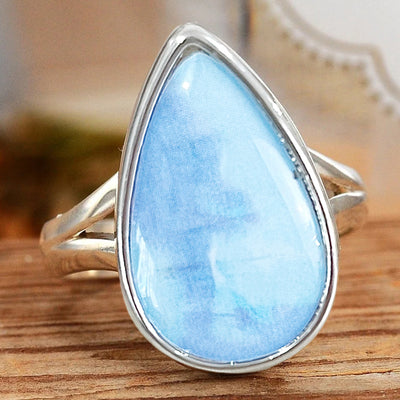 Silver light blue teardrop cabochon ring matching main wood surface shot