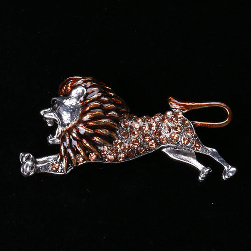 Close front view showing a side-profile running lion with a textured mane and crystal-set body