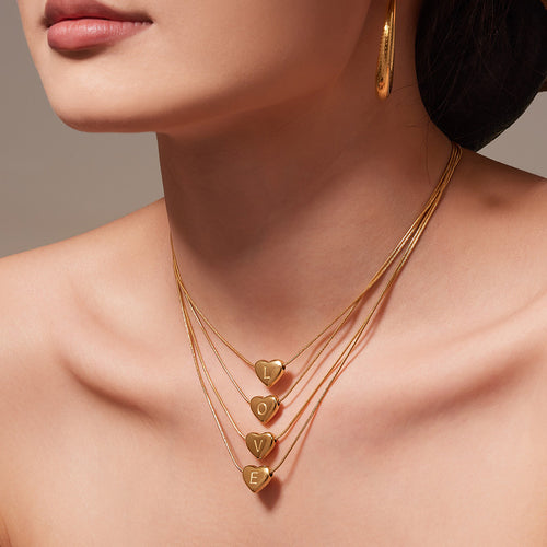 Model wearing gold letter heart pendant necklace close-up