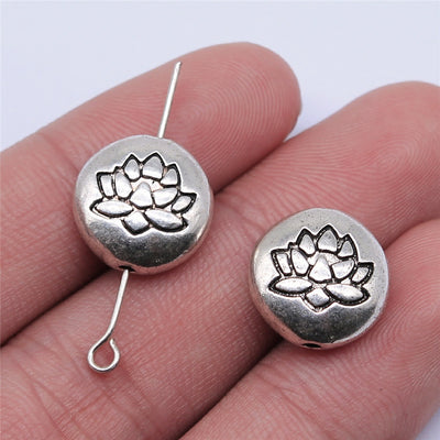 Hand-held front and back view of lotus relief round small-hole antique silver metal bead
