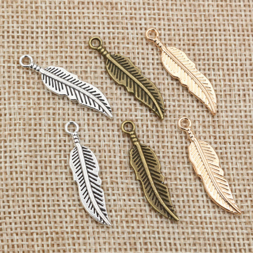 Slender feather charms arranged to show surface details